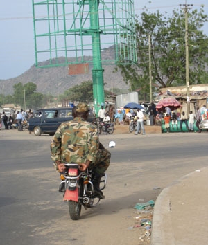 A South Sudanese soldier on a motorcycle taxi.