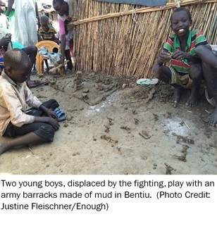 Two young boys displaced by the fighting play with an army barracks made of mud in Bentiu