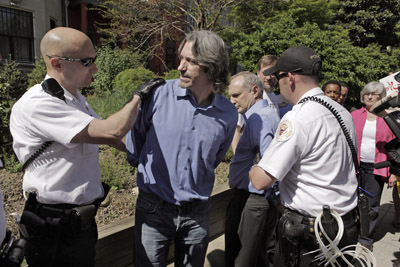 Enough co-Founder John Prendergast is handcuffed by members of the U.S. Secret Service as members of Congress and other Darfur activists look on. AP/Evan Vucci