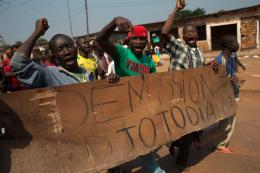 Protestors carry a sign reading 'Resign Djotodia,' in CAR.