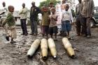 Congolese citizens look at tank shells after M23 rebel takeover in Goma.